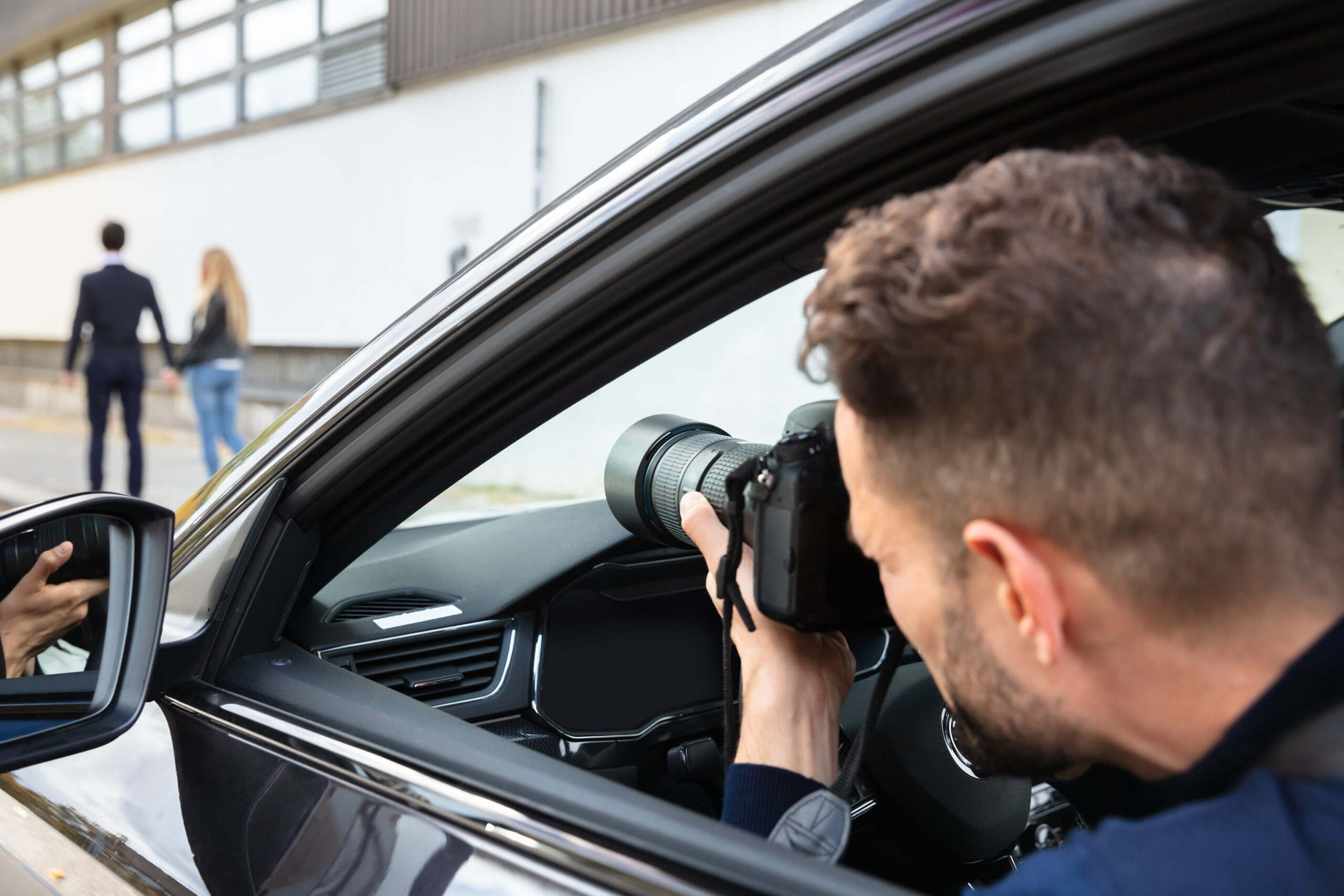 Private,Detective,Taking,Photos,Of,Man,And,Woman,On,Street